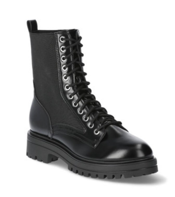 Styled collection of No Boundaries Boots including combat, riding, and Chelsea styles arranged on a textured surface